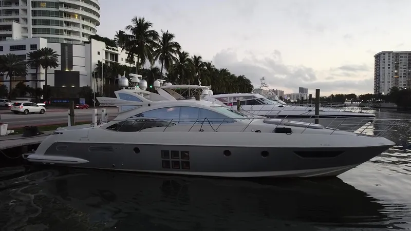 Slide: The Image of 2007 Azimut 62S yacht docked at a marina with palm trees and buildings in the background. - 14