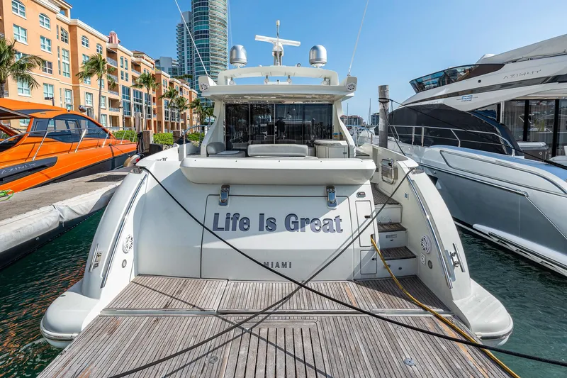 Slide: The Image of 2007 Azimut 62S yacht docked, rear view, with "Life Is Great" text, sunny marina setting. - 16