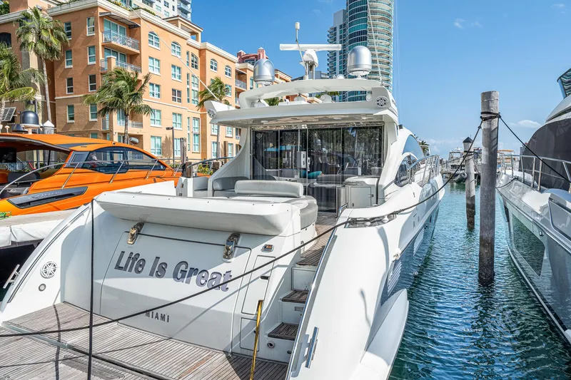 Slide: The Image of 2007 Azimut 62S yacht docked in Miami marina with cityscape background. - 17