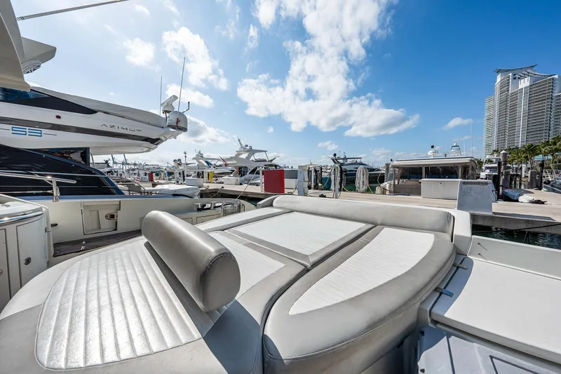 Slide: The Image of 2007 Azimut 62S yacht at marina with luxurious seating, clear skies, and cityscape backdrop. - 19