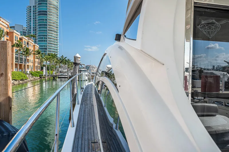 Slide: The Image of 2007 Azimut 62S yacht docked in a scenic marina with modern buildings. - 28