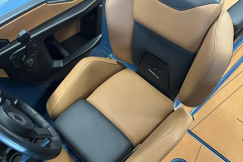 Slide: The Image of 2025 Axis A245 boat interior with tan and black seating, steering wheel, and dashboard. - 10