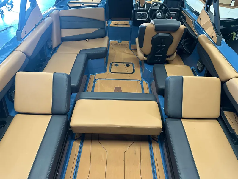 Slide: The Image of 2025 Axis A245 boat interior with tan and blue seating, modern design. - 11