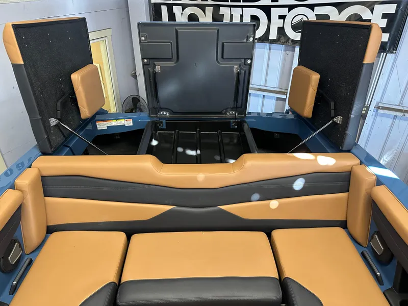 Slide: The Image of 2025 Axis A245 boat interior with tan and black seating, open storage compartments. - 6