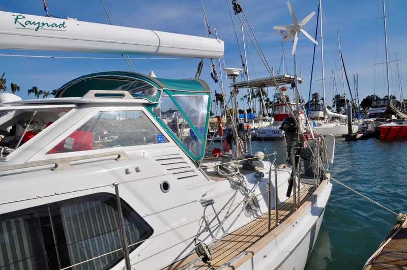 Slide: The Image of Roger Hill 2000 Cruising Cutter docked in a marina, featuring a sleek design and wind turbine. - 10