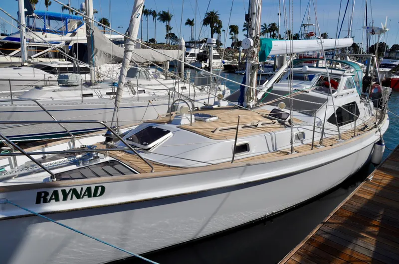 Slide: The Image of 2000 Roger Hill Cruising Cutter docked at marina, featuring sleek design and wooden deck. - 13