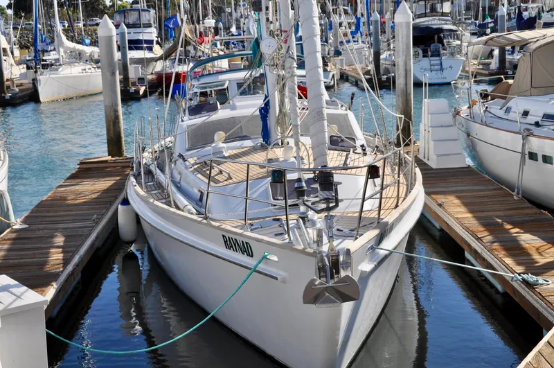 Slide: The Image of Roger Hill 2000 Cruising Cutter docked in a marina, surrounded by other boats. - 14
