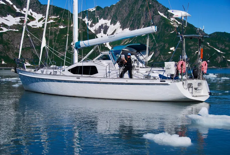 Slide: The Image of Sailing yacht "Roger Hill Cruising Cutter" in icy waters, surrounded by snow-capped mountains. - 2