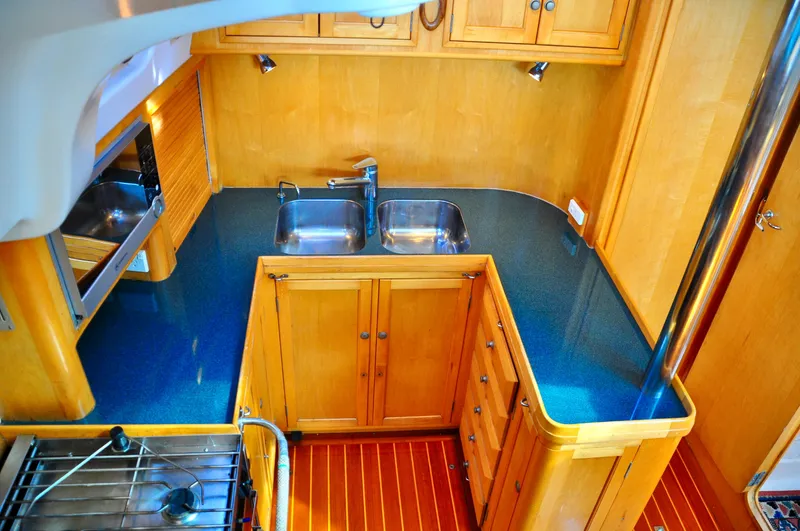 Slide: The Image of Wooden kitchen interior of 2000 Roger Hill Cruising Cutter with dual sinks and stove. - 24