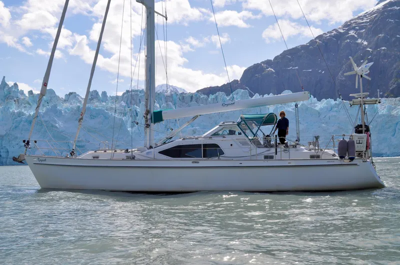 Slide: The Image of Roger Hill 2000 Cruising Cutter sailing near icy glacier backdrop. - 3