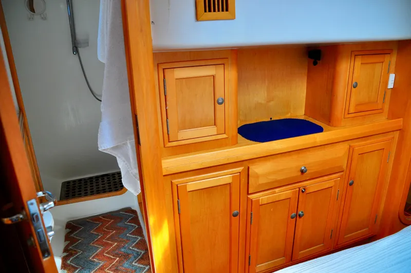Slide: The Image of Interior of 2000 Roger Hill Cruising Cutter with wooden cabinetry and shower area. - 32