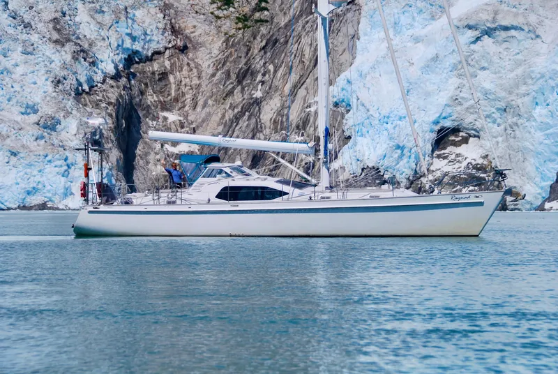 Slide: The Image of Roger Hill 2000 Cruising Cutter sailing near icy cliffs in calm waters. - 4