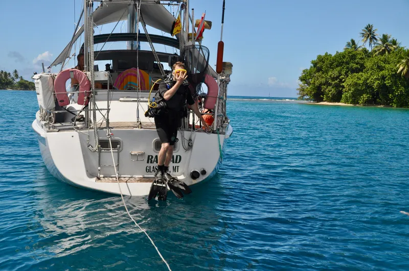 Slide: The Image of Diver preparing to enter water from Roger Hill Cruising Cutter, 2000, near tropical island. - 41