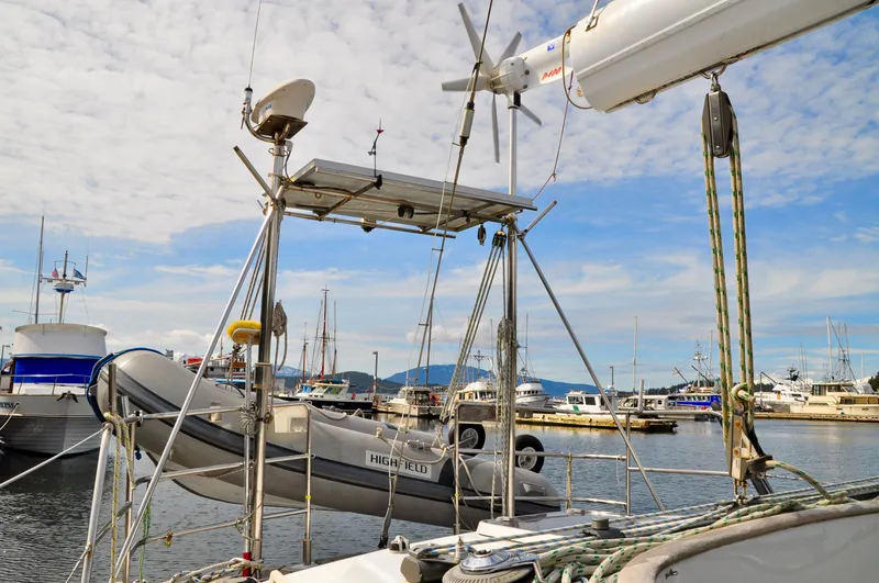 Slide: The Image of Roger Hill 2000 Cruising Cutter docked at marina with dinghy and solar panels. - 9