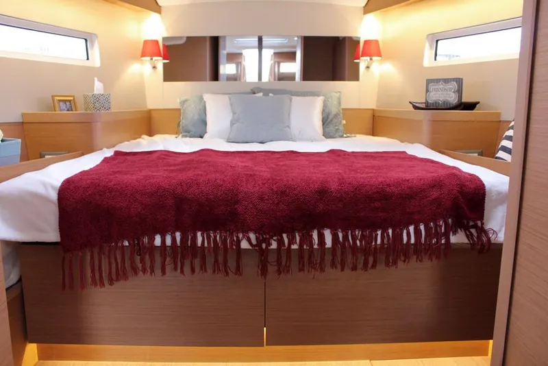 Slide: The Image of Luxurious bedroom interior of 2025 Jeanneau Sun Odyssey 440 yacht with red accents. - 2