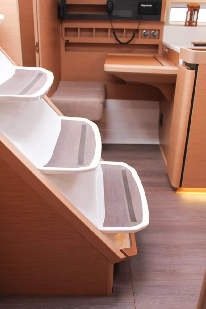 Slide: The Image of Interior of 2025 Jeanneau Sun Odyssey 440 yacht, featuring modern wooden stairs and sleek design. - 28