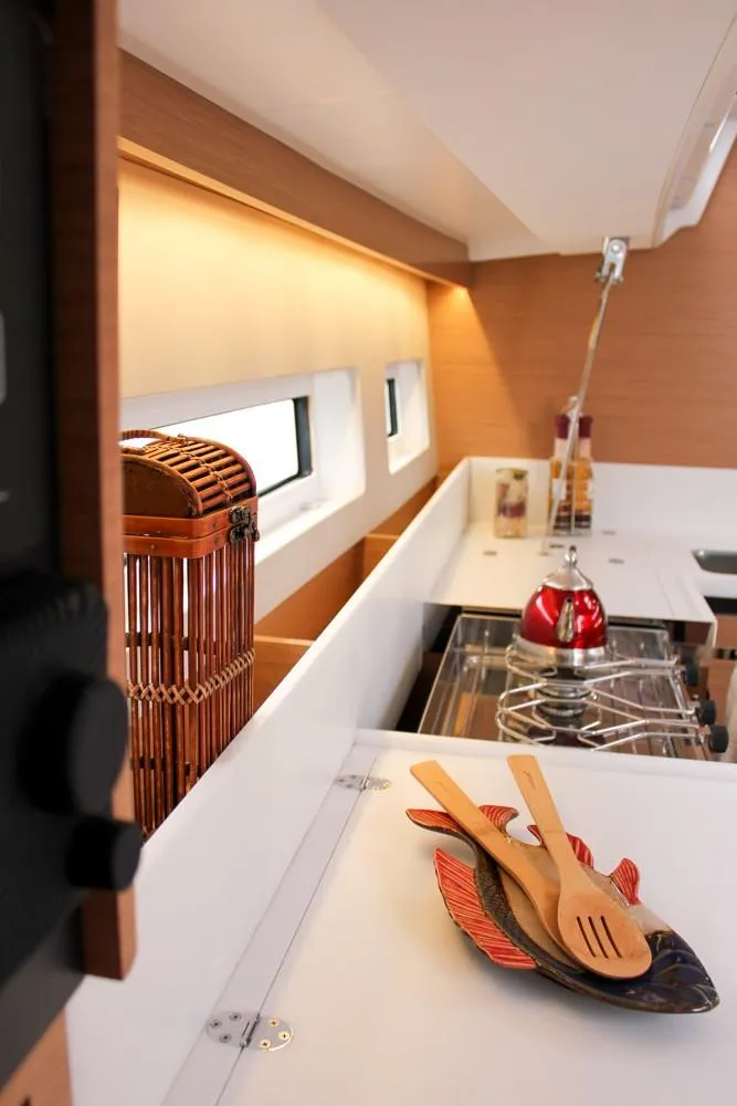Slide: The Image of 2025 Jeanneau Sun Odyssey 440 interior kitchen with modern design and wooden utensils. - 35