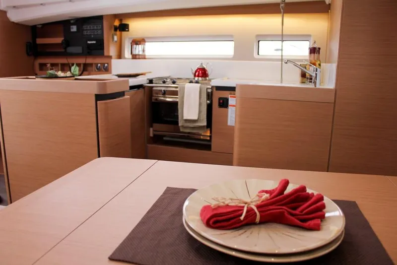 Slide: The Image of Interior of 2025 Jeanneau Sun Odyssey 440 yacht, featuring a modern kitchen and dining area. - 38