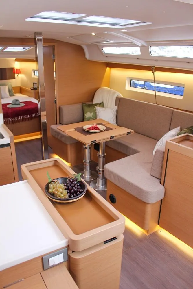 Slide: The Image of 2025 Jeanneau Sun Odyssey 440 interior with modern seating, dining area, and natural lighting. - 4