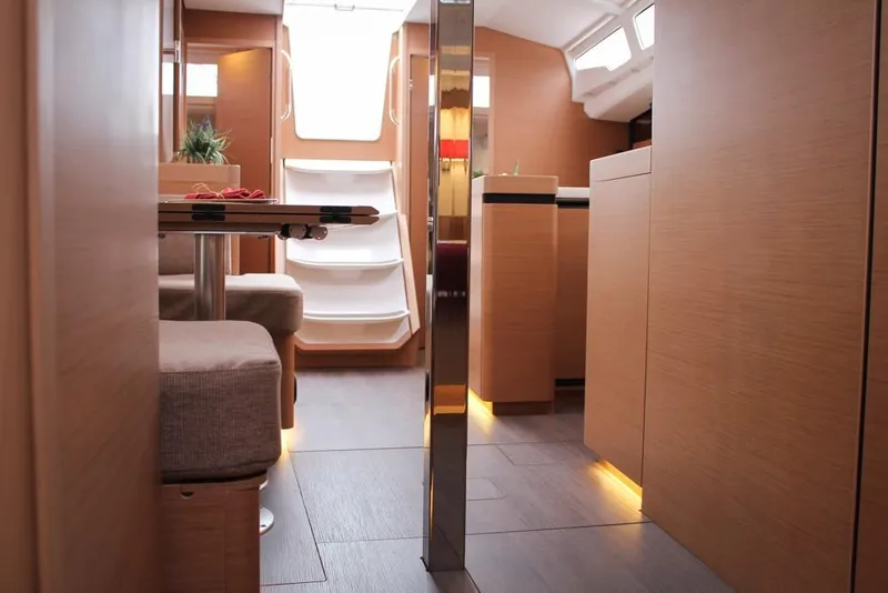 Slide: The Image of Interior of 2025 Jeanneau Sun Odyssey 440 yacht, featuring modern wood finish and ambient lighting. - 12