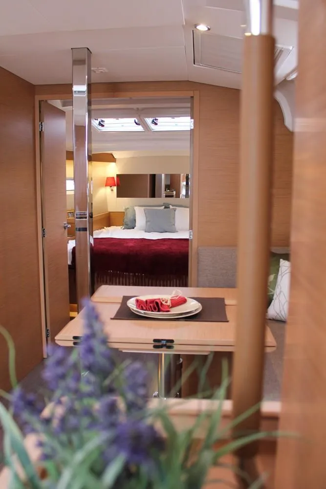 Slide: The Image of Interior of 2025 Jeanneau Sun Odyssey 440 yacht, featuring a cozy cabin and dining area. - 21