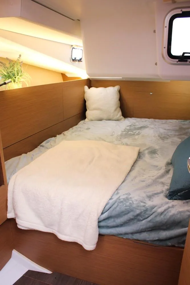 Slide: The Image of Cozy cabin interior of 2025 Jeanneau Sun Odyssey 440 sailboat with bed and window. - 25