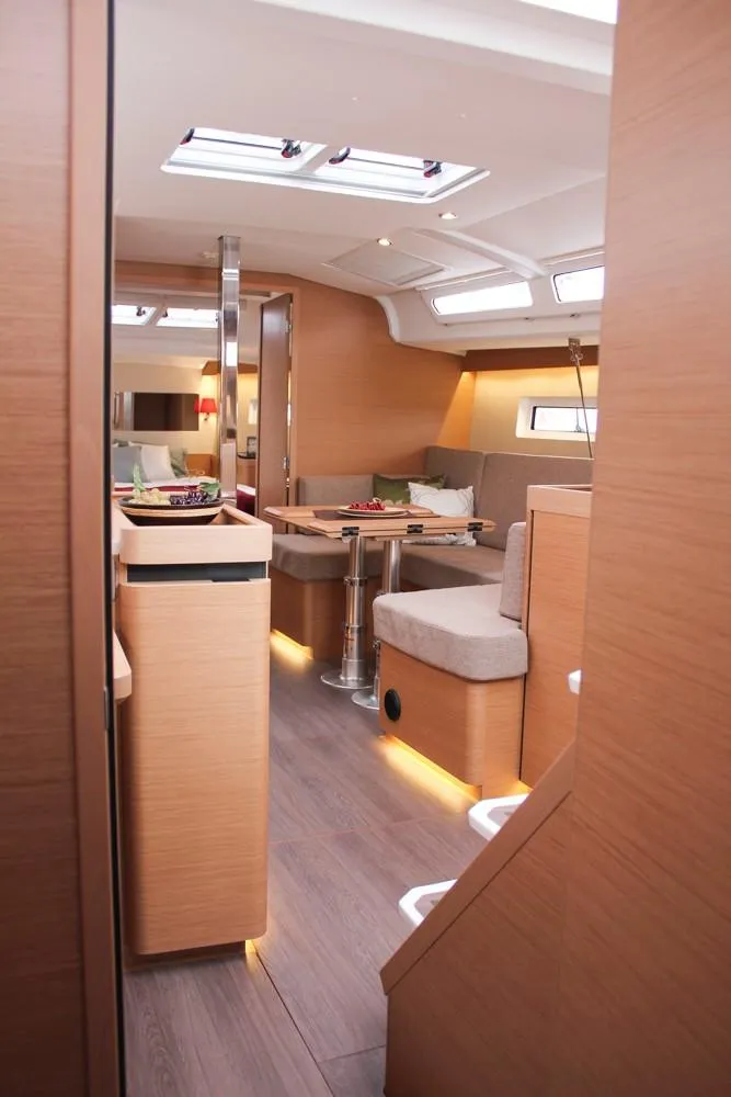 Slide: The Image of Interior of 2025 Jeanneau Sun Odyssey 440 yacht, featuring modern wood finishes and cozy seating. - 33