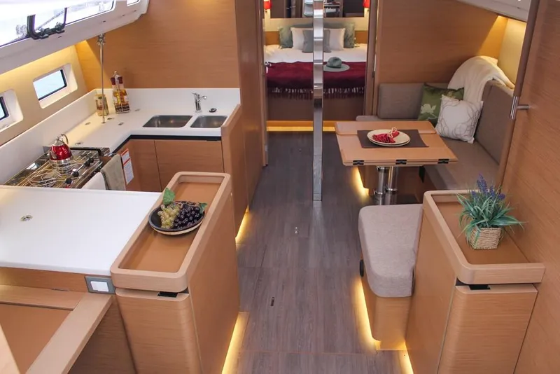 Slide: The Image of Interior of 2025 Jeanneau Sun Odyssey 440 yacht, featuring modern kitchen and cozy dining area. - 1