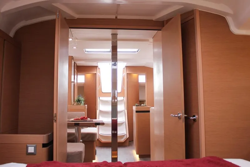 Slide: The Image of 2025 Jeanneau Sun Odyssey 440 interior with modern wood finish and cozy seating area. - 11