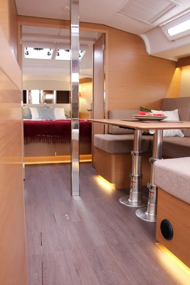 Slide: The Image of Interior of 2025 Jeanneau Sun Odyssey 440 yacht, featuring modern wood finishes and cozy seating. - 44