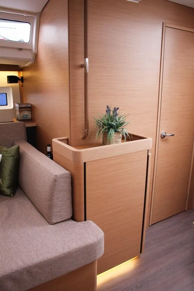 Slide: The Image of 2025 Jeanneau Sun Odyssey 440 interior with modern wood finish and cozy seating area. - 7