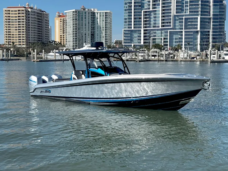 Slide: The Image of 2020 Nor-Tech 340 Sport Open Center Console boat on water, city skyline background. - 0