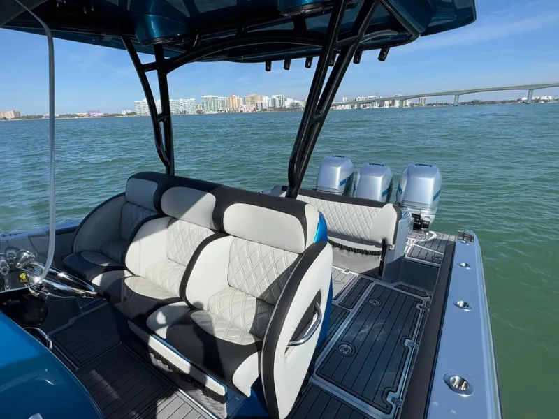 Slide: The Image of 2020 Nor-Tech 340 Sport Open Center Console boat on water, featuring luxurious seating and triple engines. - 7