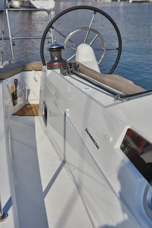 Slide: The Image of 2025 Jeanneau Sun Odyssey 410 yacht cockpit with steering wheel and winch, docked at marina. - 14