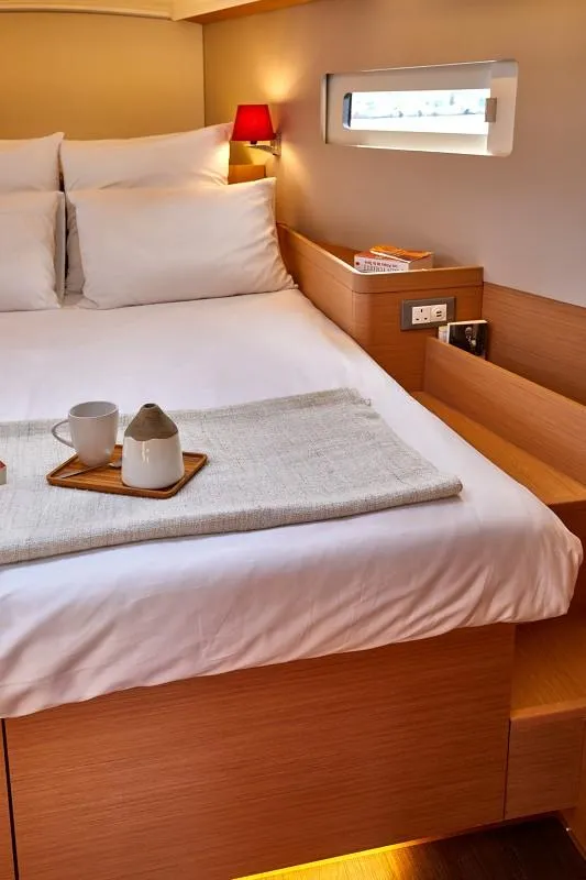 Slide: The Image of Cozy cabin interior of 2025 Jeanneau Sun Odyssey 410 yacht with bed and window. - 12