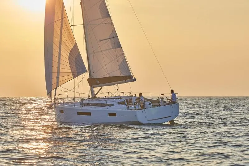 Slide: The Image of 2025 Jeanneau Sun Odyssey 410 sailing at sunset on open water. - 14