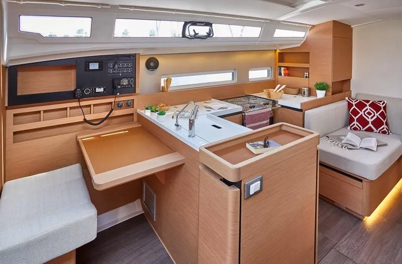 Slide: The Image of Interior of 2025 Jeanneau Sun Odyssey 410 yacht, featuring modern kitchen and seating area. - 2