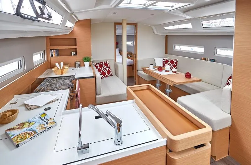 Slide: The Image of Interior of 2025 Jeanneau Sun Odyssey 410 yacht, featuring modern kitchen and cozy seating area. - 5