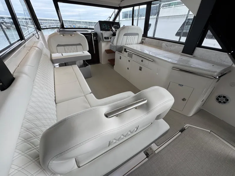 Slide: The Image of 2023 Regal 360 Grande Coupe interior with luxurious seating and modern helm. - 12