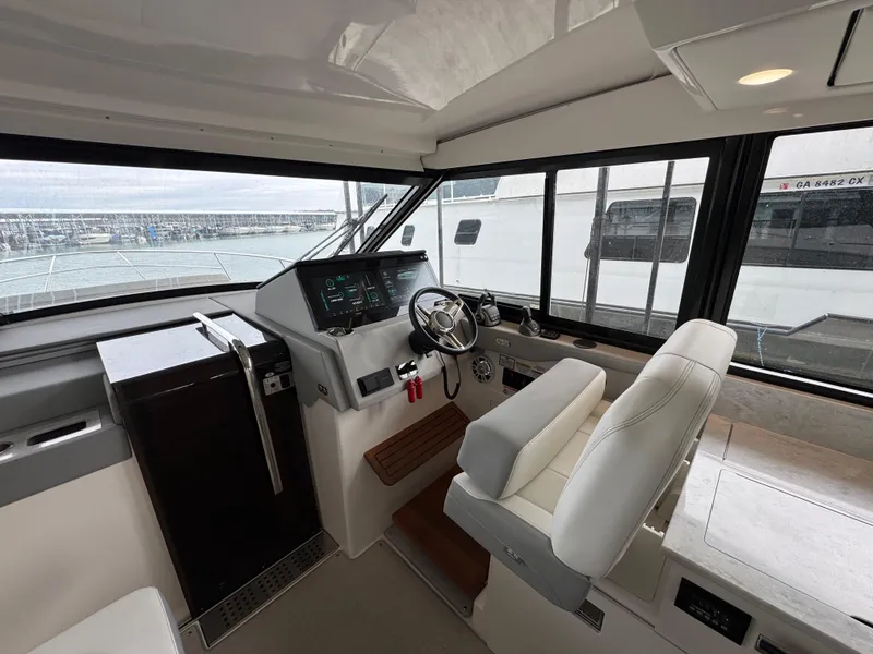 Slide: The Image of 2023 Regal 360 Grande Coupe helm with modern controls and panoramic windows. - 13