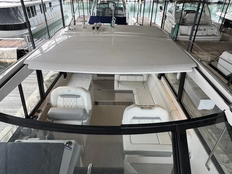 Slide: The Image of 2023 Regal 360 Grande Coupe interior with white seating, docked in a marina. - 16