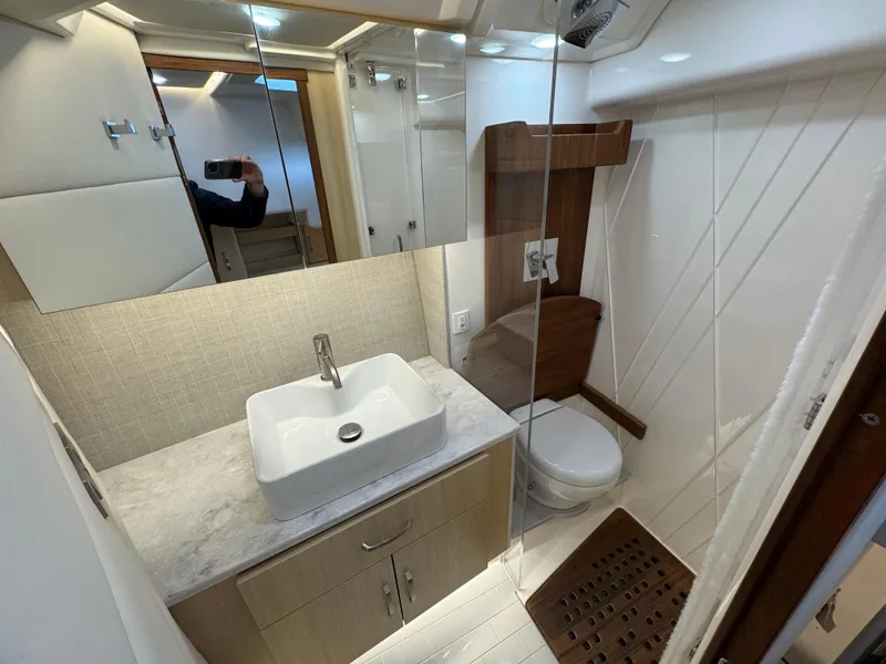 Slide: The Image of 2023 Regal 360 Grande Coupe bathroom with modern sink, toilet, and wooden accents. - 19