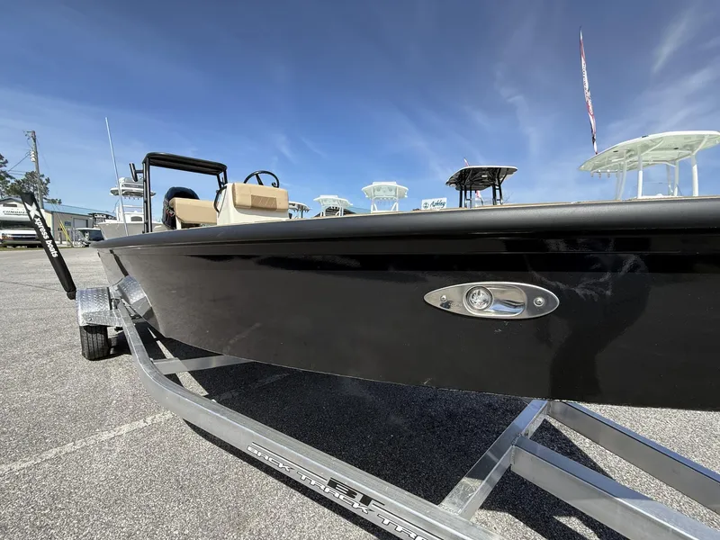 Slide: The Image of 2025 Xpress Skiff 185 boat on trailer under clear blue sky. - 5