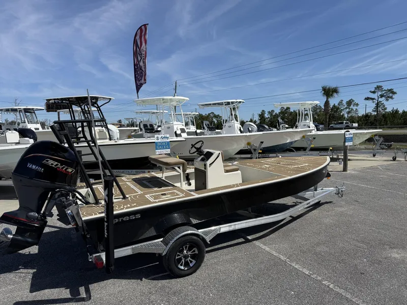 Slide: The Image of 2025 Xpress Skiff 185 boat on trailer at dealership, sunny day. - 6