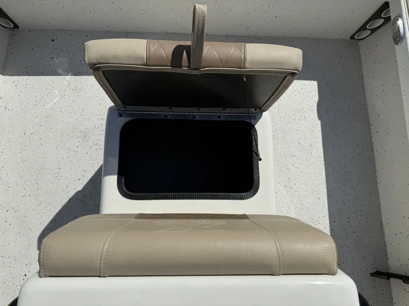 Slide: The Image of Open storage compartment on 2025 Xpress Skiff 185 boat with beige seat. - 8