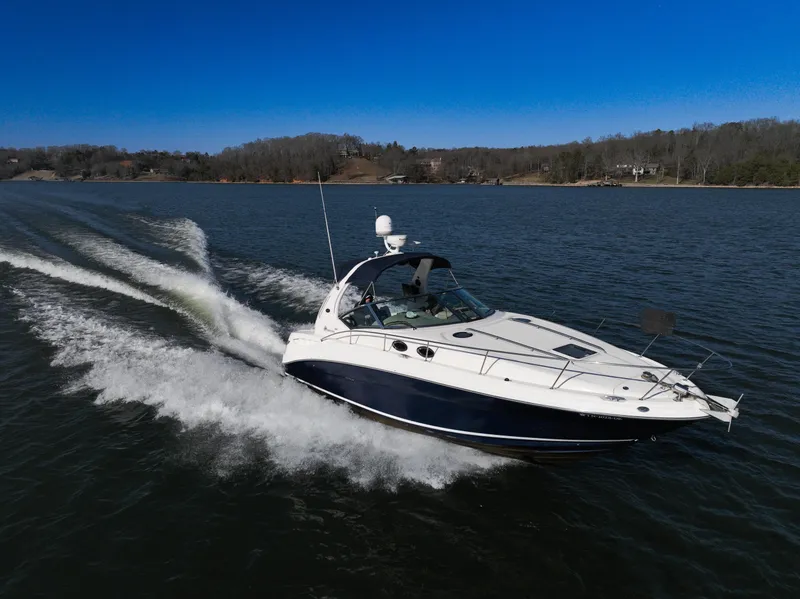 Slide: The Image of 2005 Sea Ray 320 Sundancer cruising on a lake under clear blue skies. - 1