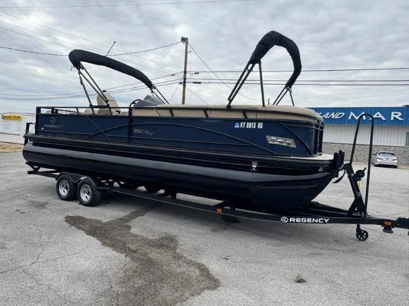 Slide: The Image of 2020 Regency 250 DL3 pontoon boat on trailer, parked outdoors. - 10