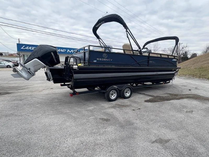 Slide: The Image of 2020 Regency 250 DL3 pontoon boat on trailer, parked outdoors under cloudy sky. - 16
