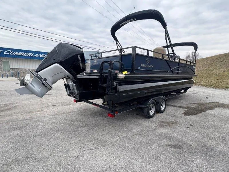 Slide: The Image of 2020 Regency 250 DL3 pontoon boat on trailer, parked outdoors. - 18