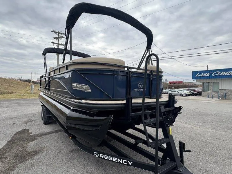 Slide: The Image of 2020 Regency 250 DL3 pontoon boat on trailer, parked near Lake Cumberland dealership. - 21